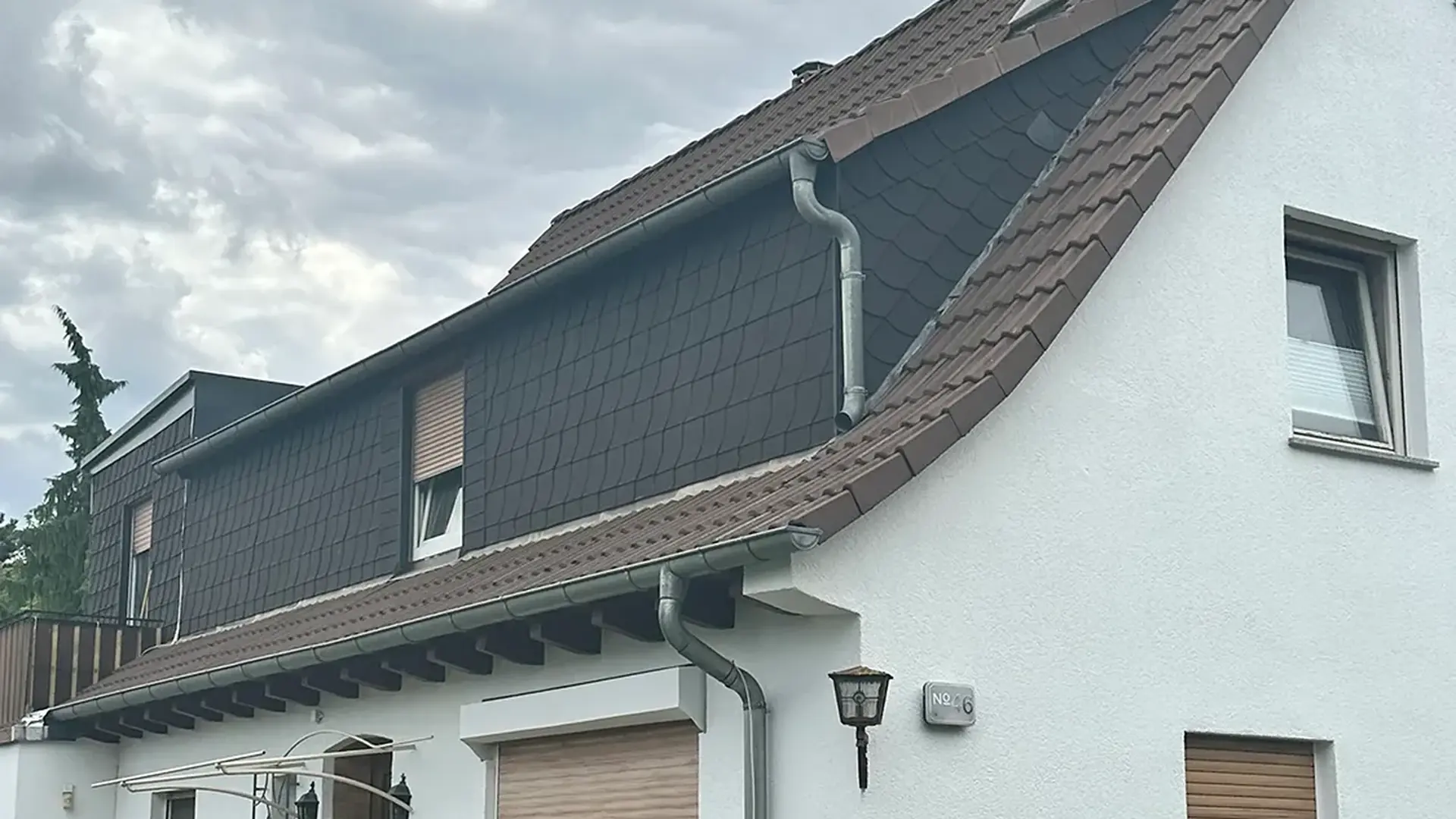 Saniertes Wohnhaus mit neuer Fassade und beschichtetem Dach